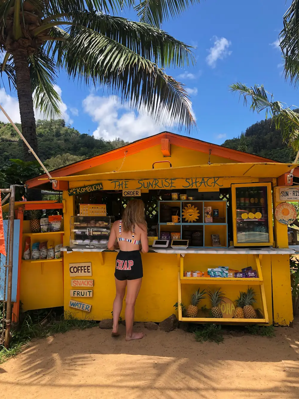 Women getting an Acai bowl at a beach shack in Hawaii